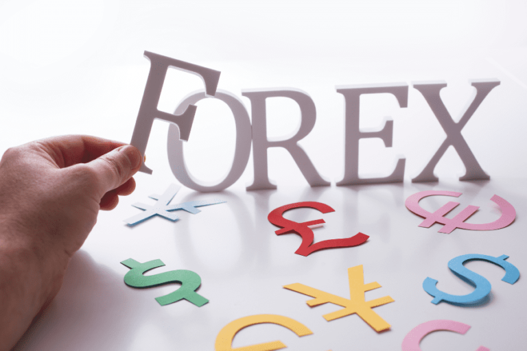 Man placing Forex lettering on white platform with currency symbols spread around the lettering.