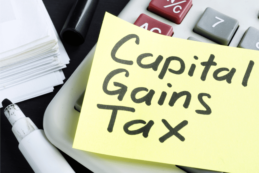 A yellow post it with 'Capital Gains Tax' written on it, stuck to a calculator to calculate tax on Forex Trading Profits